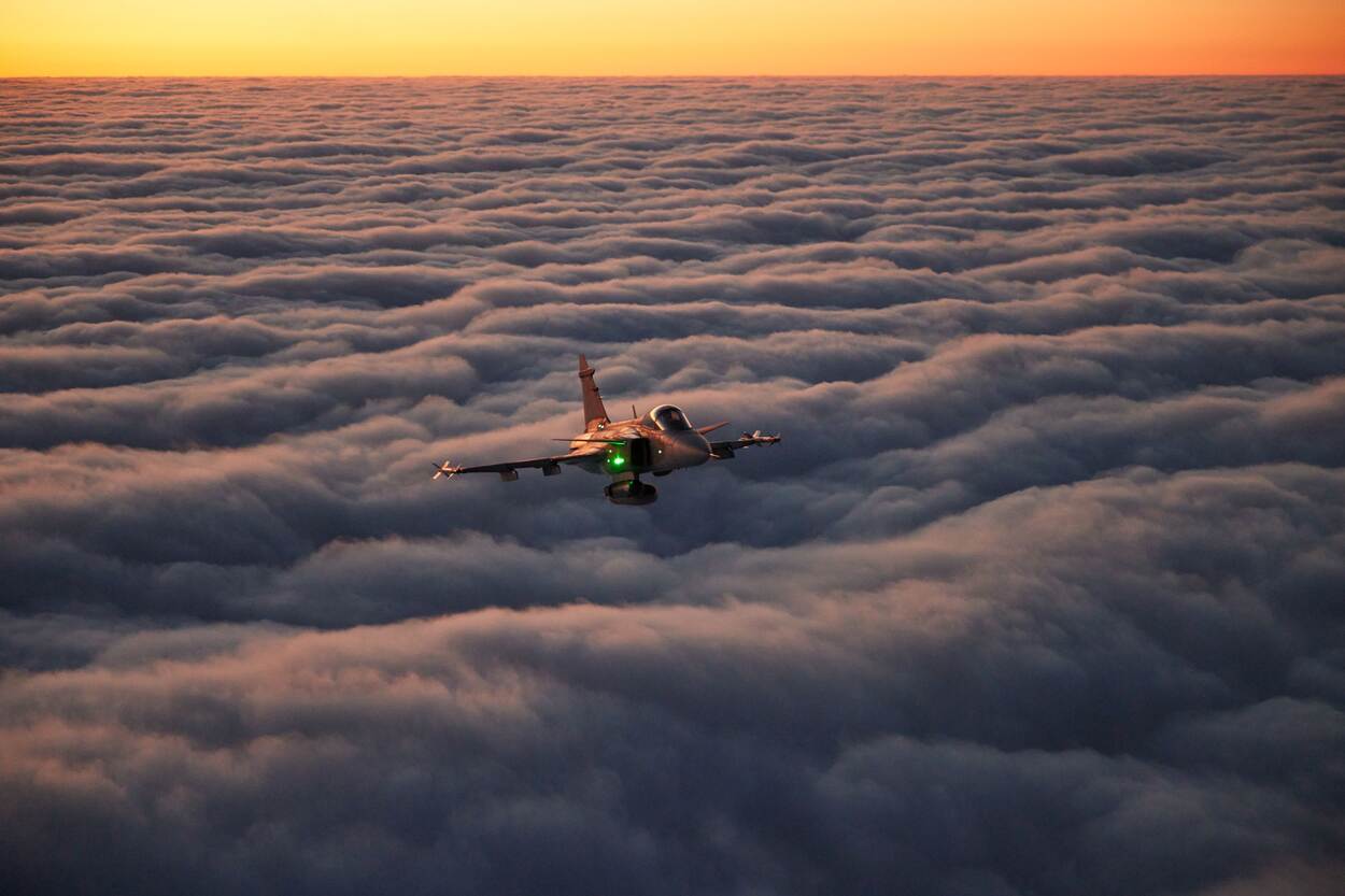Een Tsjechische Saab Gripen vliegt boven het wolkendek.