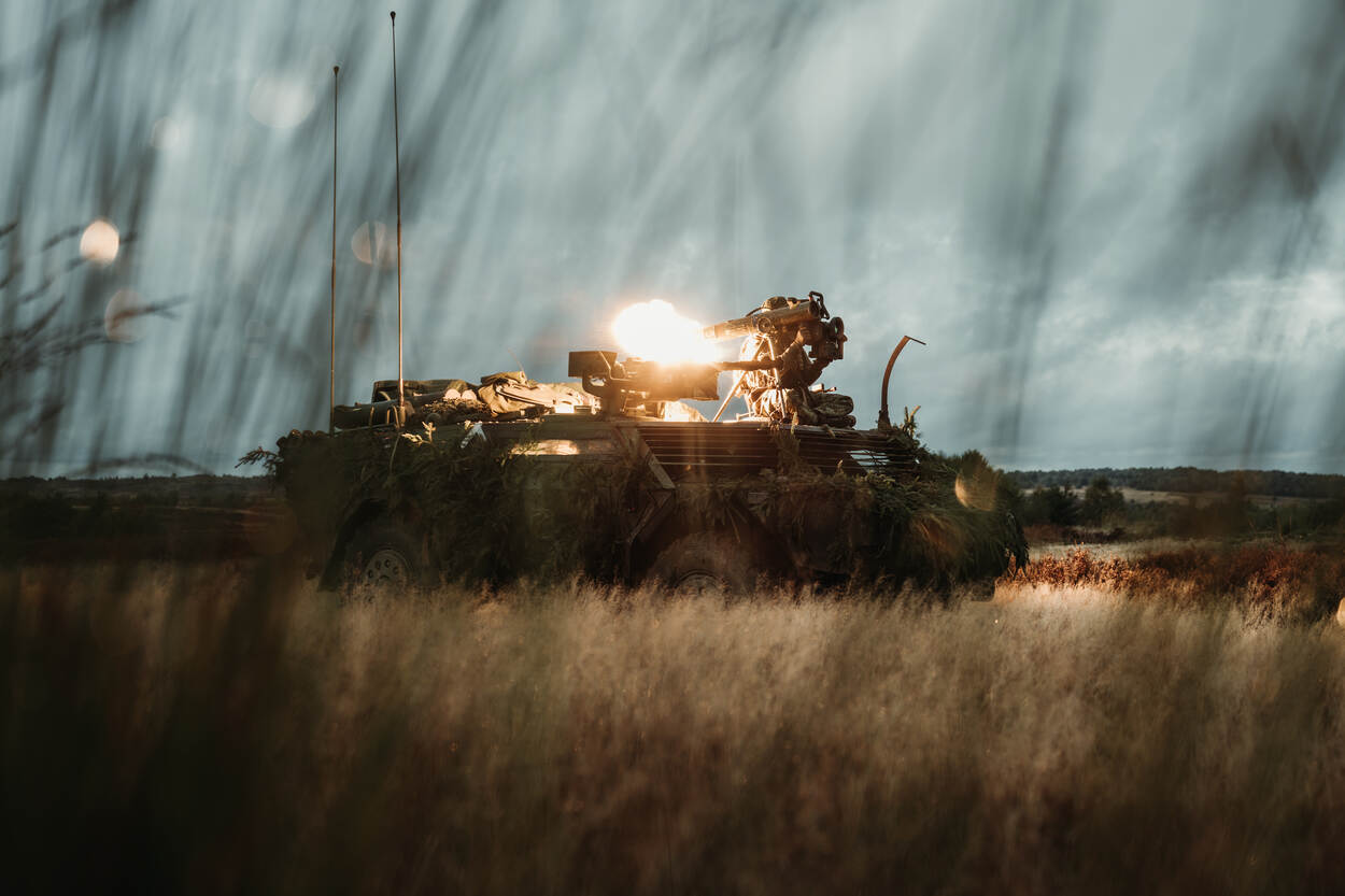 Militair vuurt een Spike anti-tankwapen af zittend op een Fennek verkenningsvoertuig.