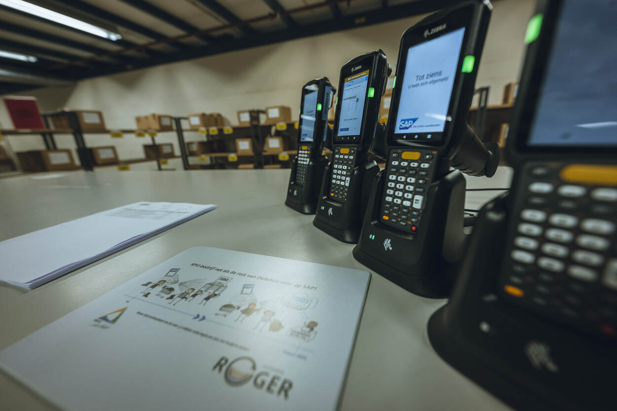 Op een tafel ligt een poster over SAP en staat een aantal  scanners.