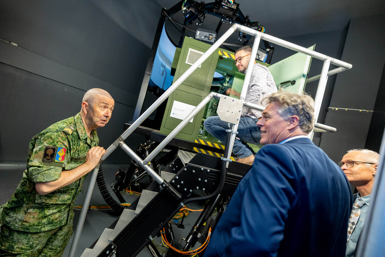 4 mensen overleggen voor een simulator