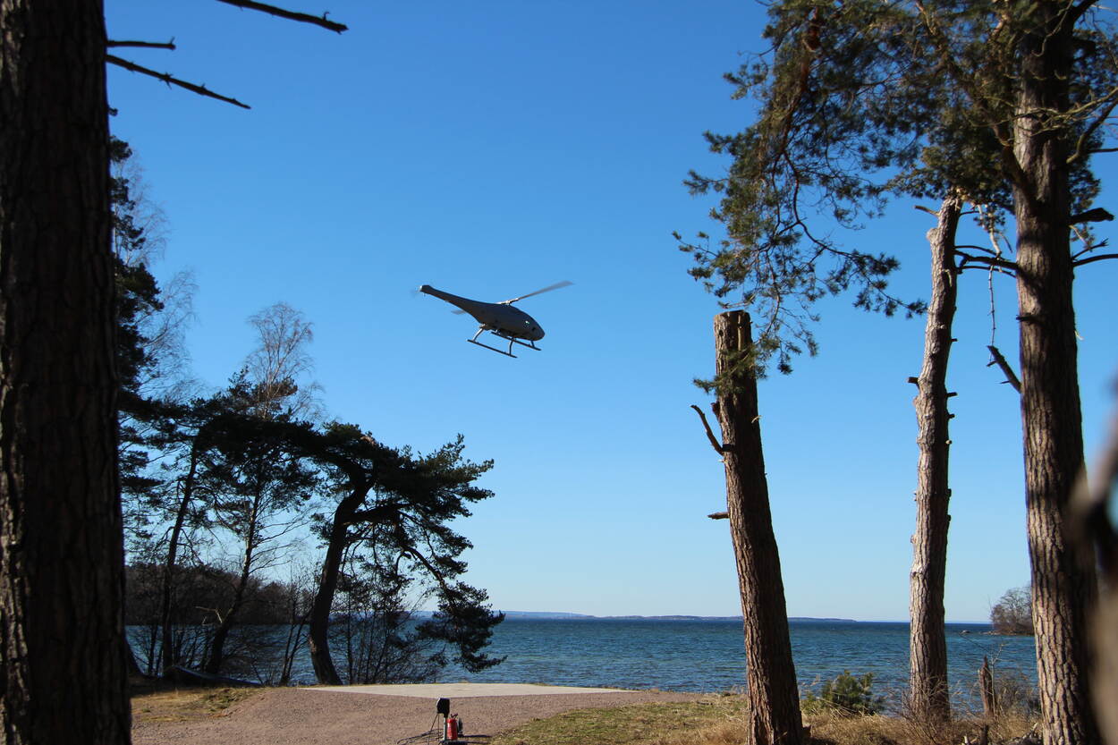 De helikopterdrone vliegt boven een meer in Zweden.