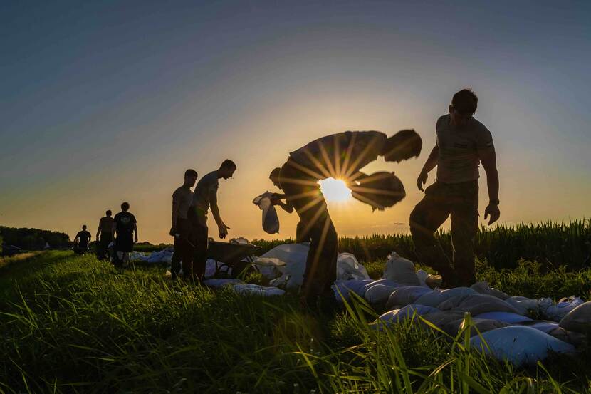Militairen leggen zandzakken in het kader van noodhulp in Nederland
