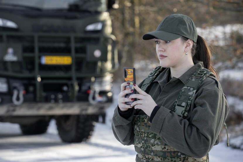 Op de foto een vrouwelijke fractiemedewerker die met haar mobieltjes een foto neemt.
