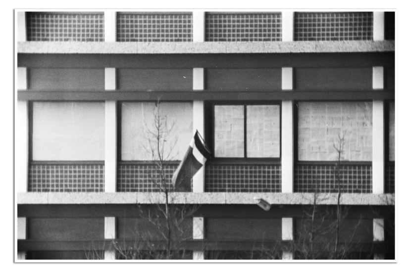 Gebouw met afgeplakte ramen en Zuid-Molukse vlag.