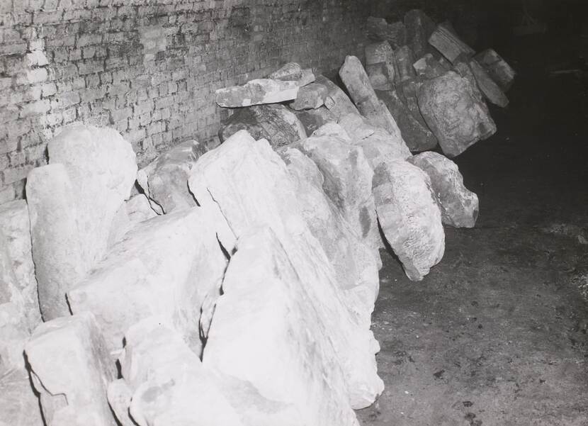 Overbelichte foto van uitgebeitelde ornamenten tegen de wand in een kelder.