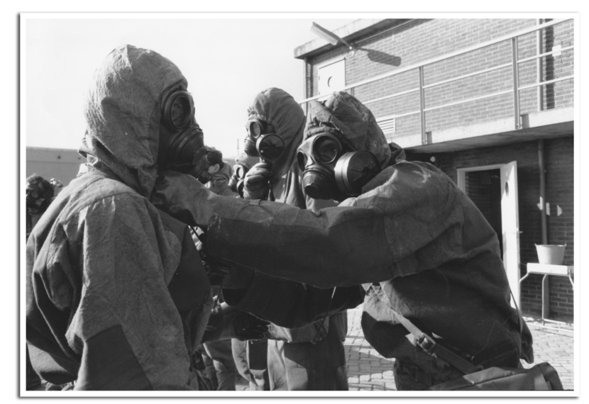 Vier mannen met een beschermend pak en gasmasker op testen de luchtdichtheid.