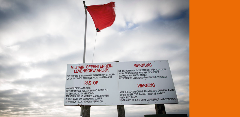 Een bord met waarschuwingen erop en een rode vlag