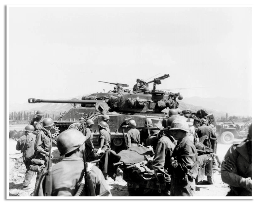 Gewonde Amerikaanse soldaten worden geëvacueerd, terwijl M-4 tanks naar het front trekken bij Koemchoen.