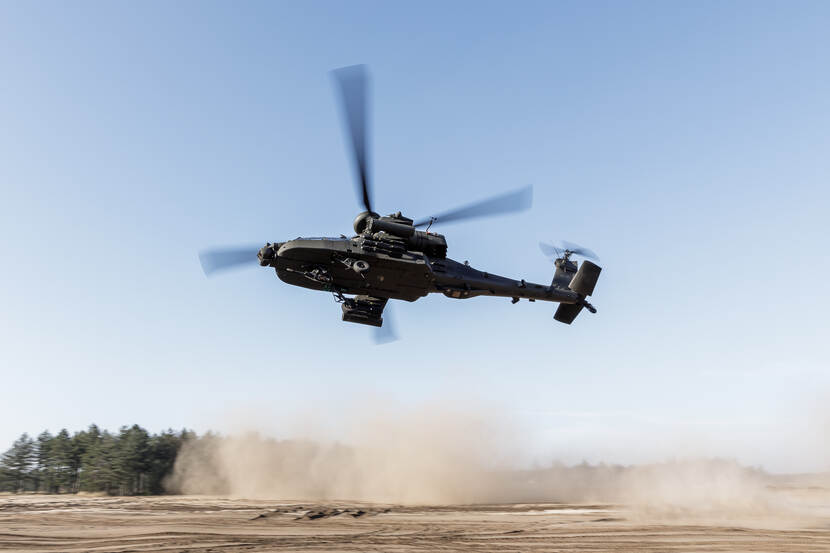 Een Apache gevechtshelikopter laat in een scherpe draai zijn onderbuik zien.