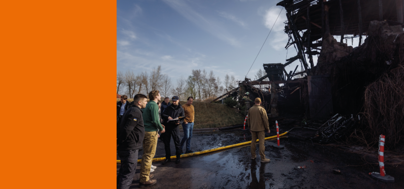 Diverse mannen kijken naar het karkas van een gebouw in Oekraïne, dat is gebombardeerd door drones.