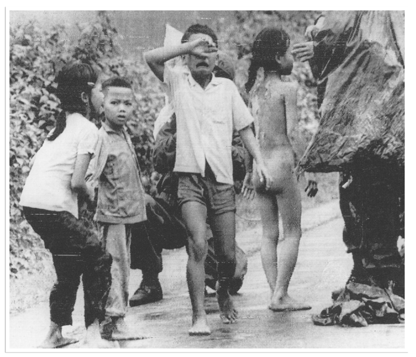 geschrokken en huilende kinderen. Een naakt meisje heeft een grote brandwond op haar rug.