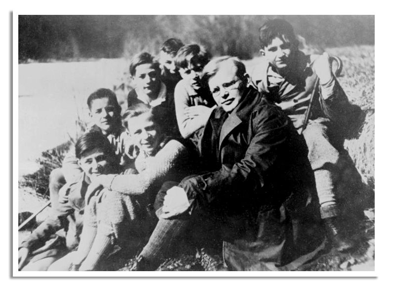 Op de voorgrond Dietrich Bonhoeffer met een groep jongeren op de achetrgrond.