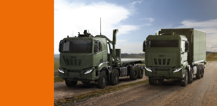 Twee militaire trucks staan naast elkaar op een onverharde weg.