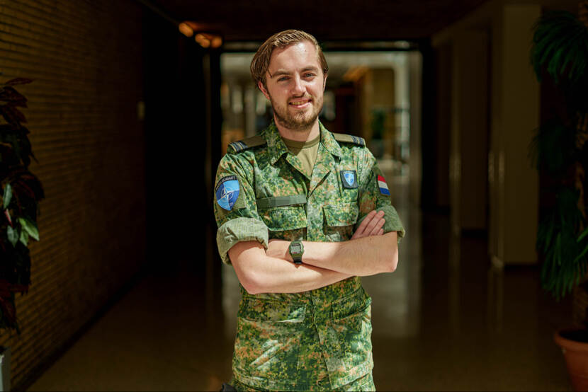 Militair met armen over elkaar kijkt vriendelijk in de lens.