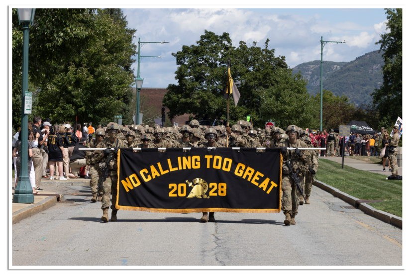 Een groep militairen met voor zich een banier met als opschrift ‘Class of 2028’.