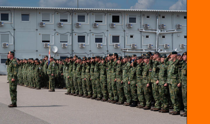 Militairen salueren tijdens een ceremonie.