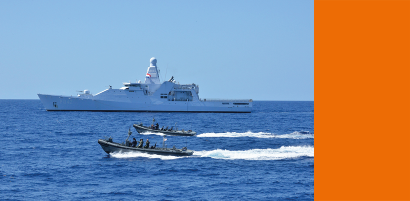 Marineschip op zee, ervoor varen 2 snelle onderscheppingsboten.