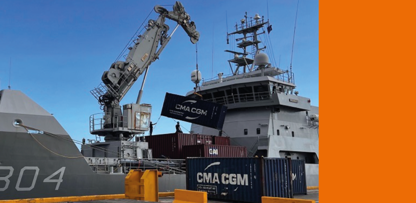 Een container wordt van een marineschip gehesen.