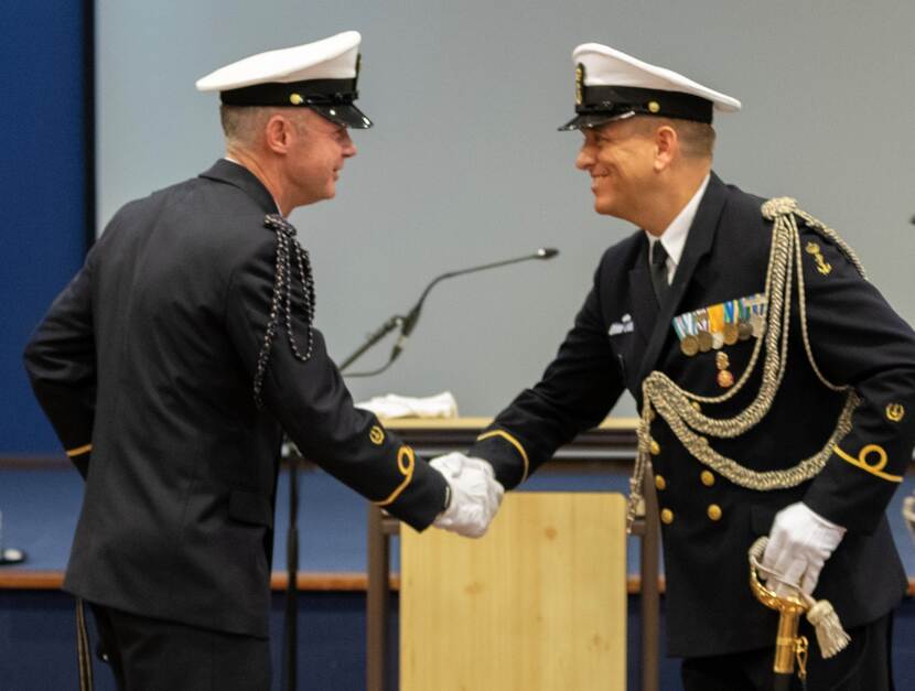 Op de foto schudden beide adjudanten elkaar de hand
