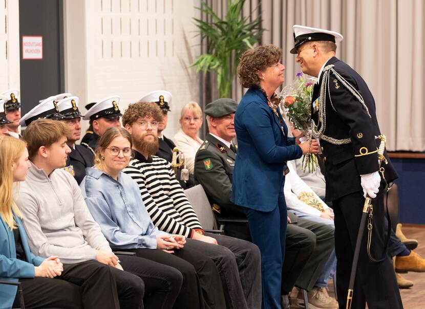 Op de foto staat adjudant Heeringa op het punt zijn vrouw een kus te geven.