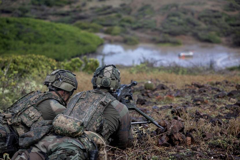 Een mitrailleurschutter met zijn helper die een doelwit observeren.