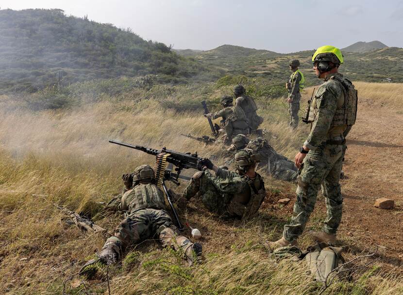 Een schutter achter een zware mitrailleur met daarachter een marinier in de weer met een 60 millimeter-mortier.