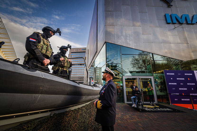 2 mariniers staan voor de bioscoop op een FRISC motorboot en zijn in gesprek met Commandant Zeestrijdkrachten vice-admiraal René Tas.
