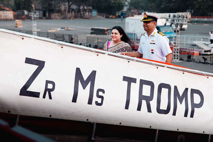 Een Indiase marineman en vrouw met sari lopen over de loopplank van Zr.Ms. Tromp.