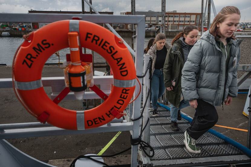 Jonge vrouwen komen via de valreep aan boord van Zr.Ms. Friesland.