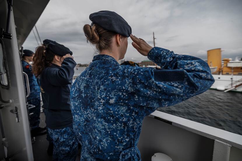 Bemanningsleden brengen de groet tijdens het vertrek uit Kopenhagen.
