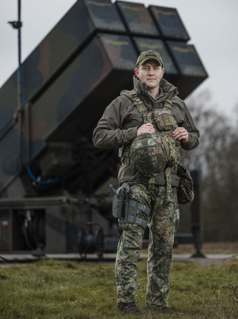 Militair staand op grasveld voor een raketlanceerinstallatie