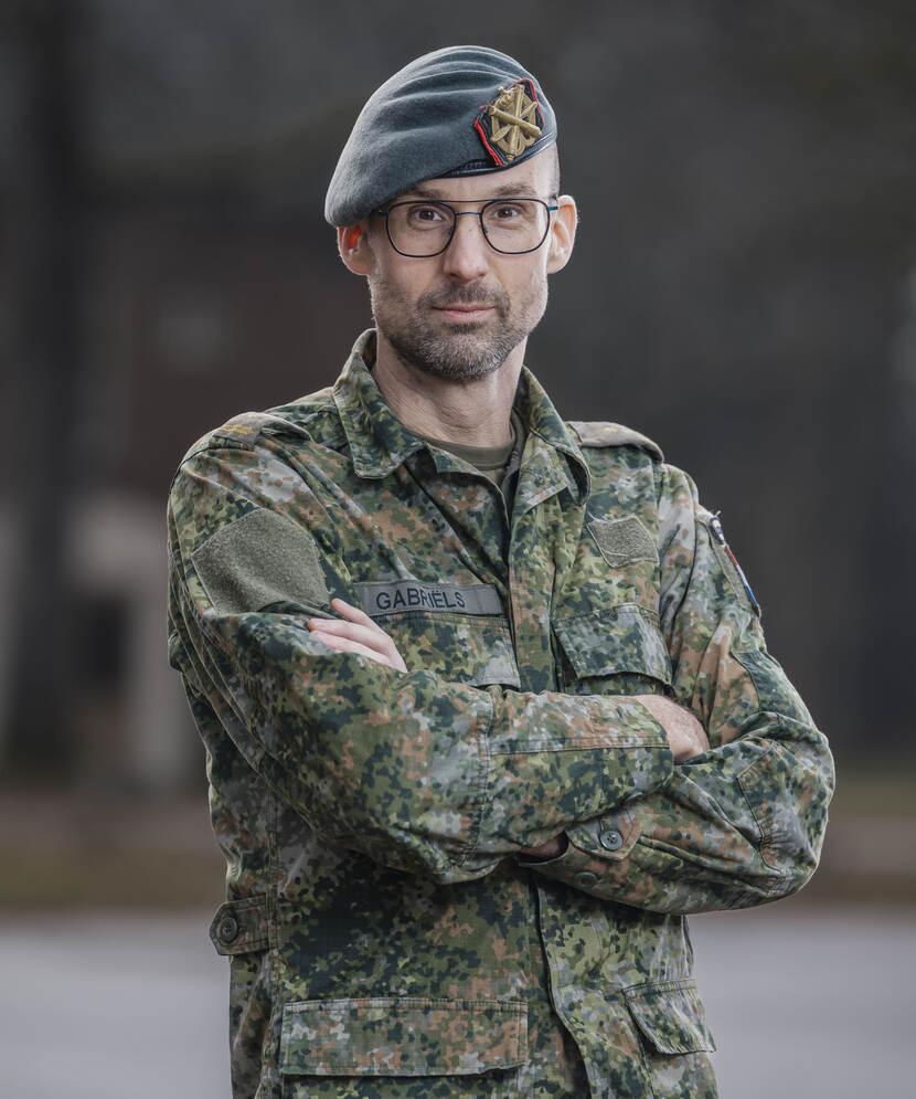 Een luitenant-kolonel in militaire outfit poseert met armen over elkaar