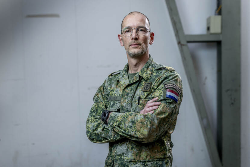 Portret van militair met bril en armen over elkaar.