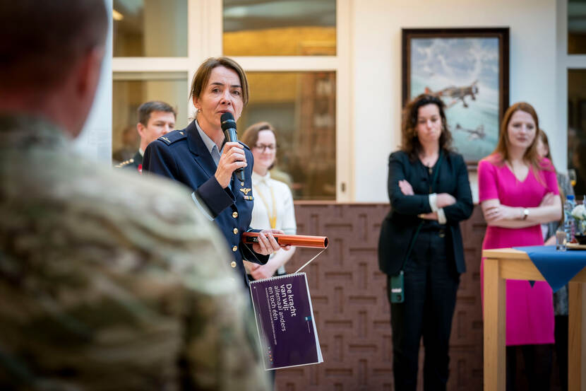 Commodore Saskia Siemensma met het estafettestokje in haar hand spreekt aanwezigen toe.