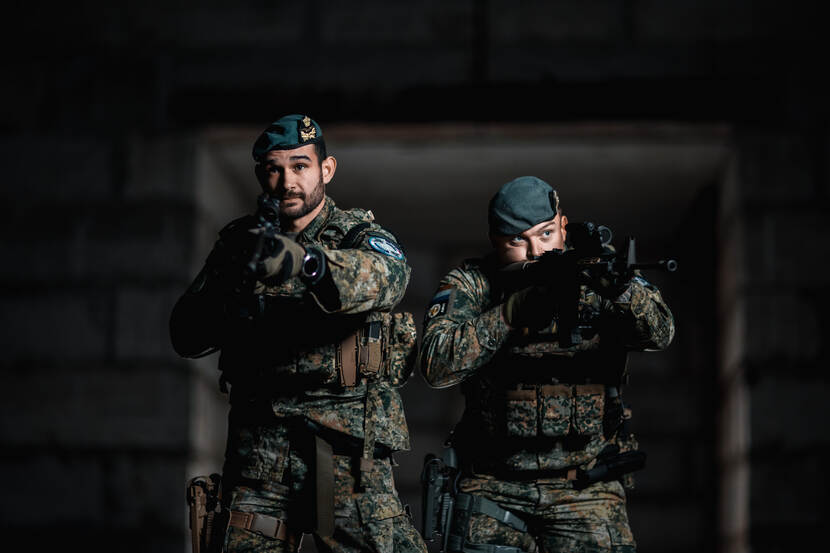 Twee militairen van de OGRV met getrokken wapen.