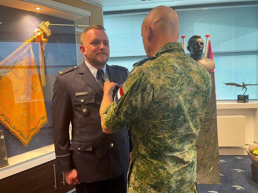 Martijn (links) krijgt de medaille opgespeld door de C-LSK.