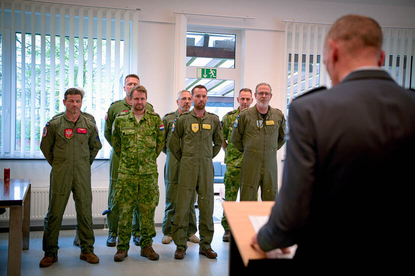 Gedecoreerde militairen luisteren naar speech.