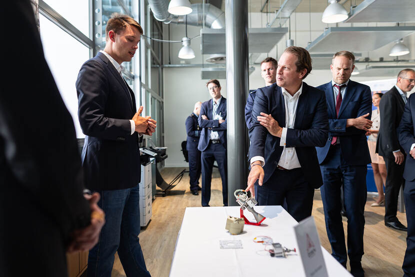 De staatssecretaris krijgt een toelichting van iemand van een bedrijf.