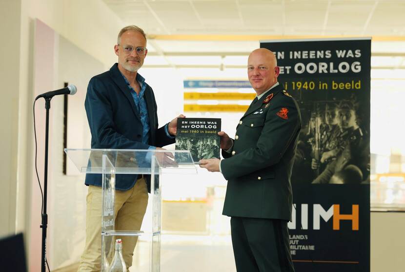 Commandant van de Nederlandse Defensie Academie, generaal-majoor Roy Sillen, neemt het eerste exemplaar van het boek in ontvangst.