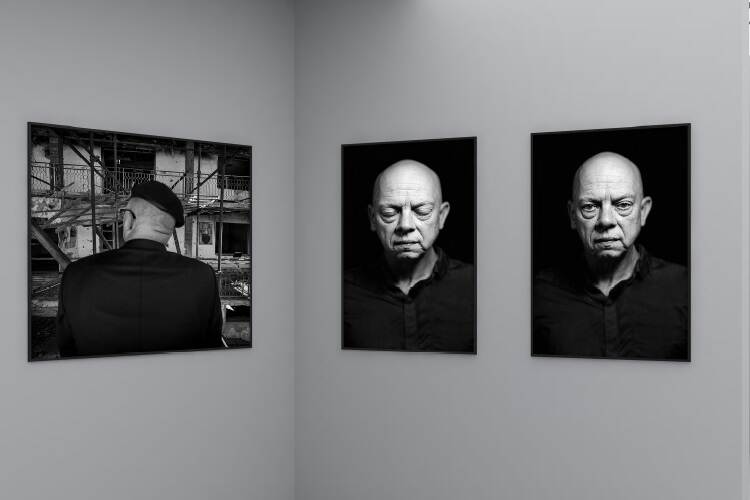 Drie zwart-witfoto’s van de tentoonstelling aan een wand.