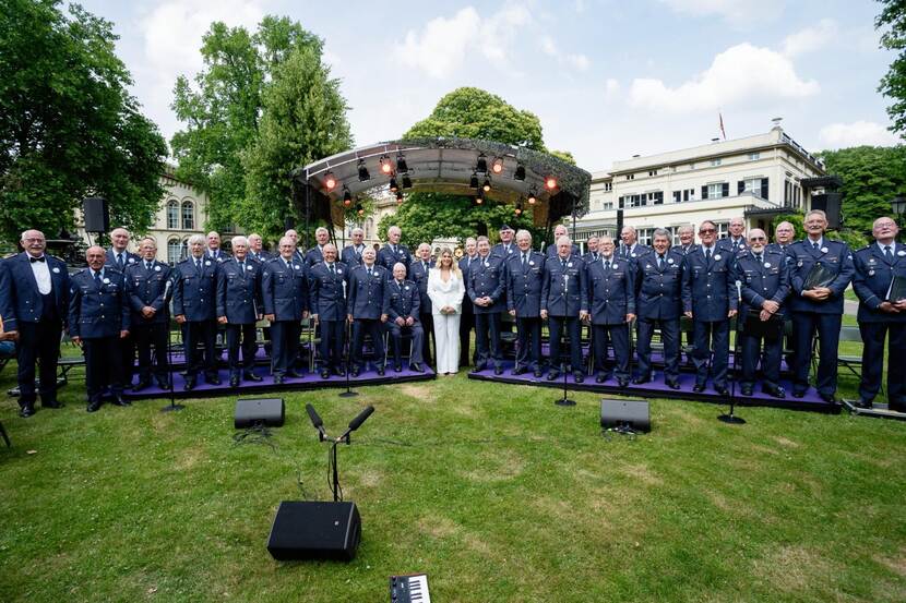 Het luchtmacht Mannenkoor opgesteld met in het midden Roxeanne Hazes.