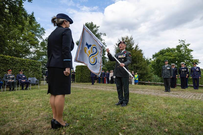 Ceremoniële overhandiging van de vlag.