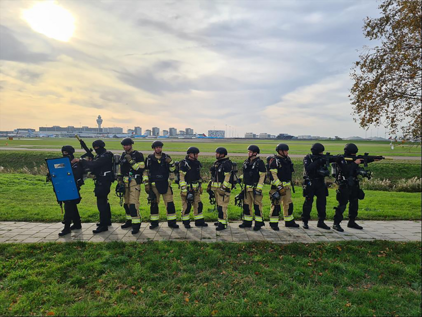 Groepsfoto van het nieuwe samenwerkingsverband tussen de Brandweer Schiphol en de Koninklijke Marechaussee.