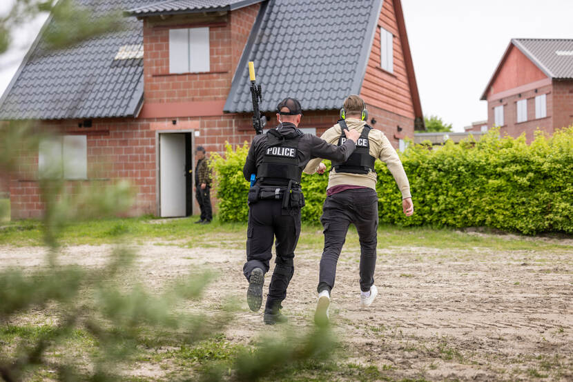 Een persoonsbeveiliger voert een iemand mee naar veiligheid.