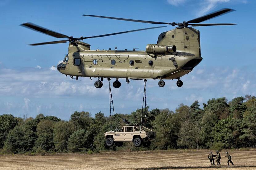 Vector terreinvoertuig onder een Chinook.