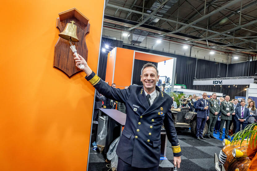 Lachende commandant COMMIT, vice-admiraal Jan Willem Hartman, luidt een scheepsbel.