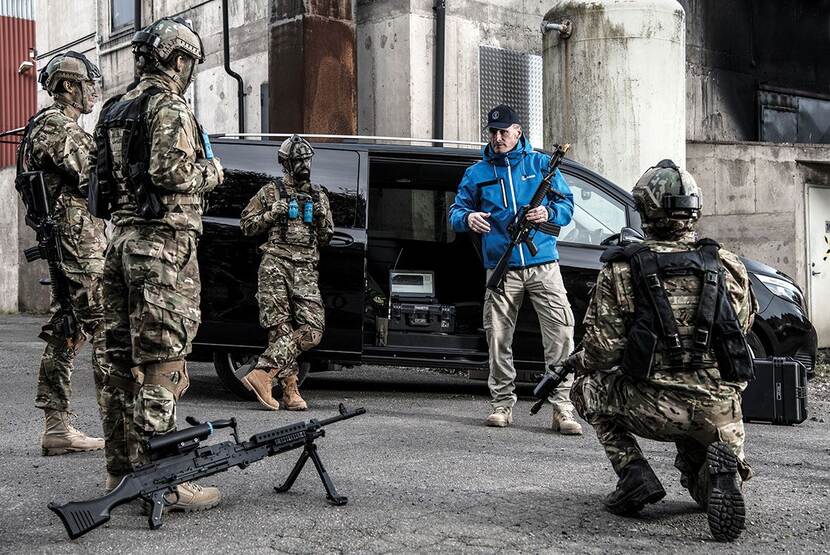 een instructeur geeft les aan militairen met lange wapens