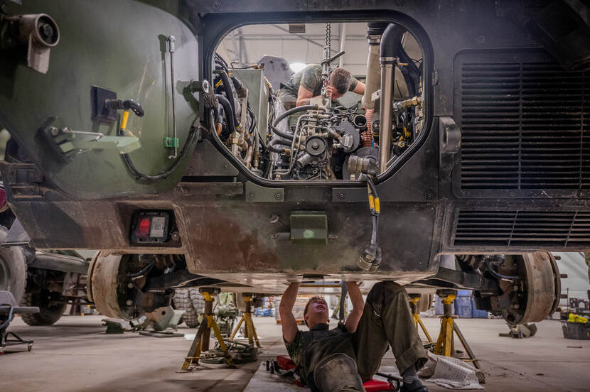 Monteurs in Litouwen sleutelen aan een Fennek tijdens oefening Iron Wolf in Litouwen.