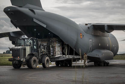 een heftruck laadt goederen uit een vliegtuig.