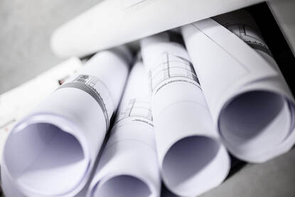 Rollen bouwtekeningen op een stapel